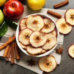 Composition with apple chips and cinnamon on grey table