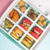Top view of a snack box with mini burgers and deep fried chicken and balls