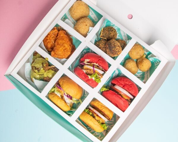 Top view of a snack box with mini burgers and deep fried chicken and balls