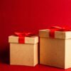 Two brown and red gift boxes on red surface