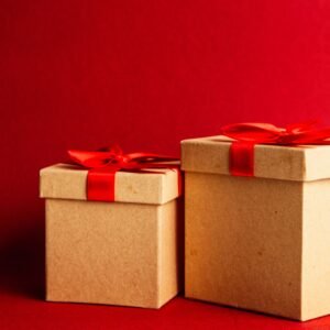Two brown and red gift boxes on red surface